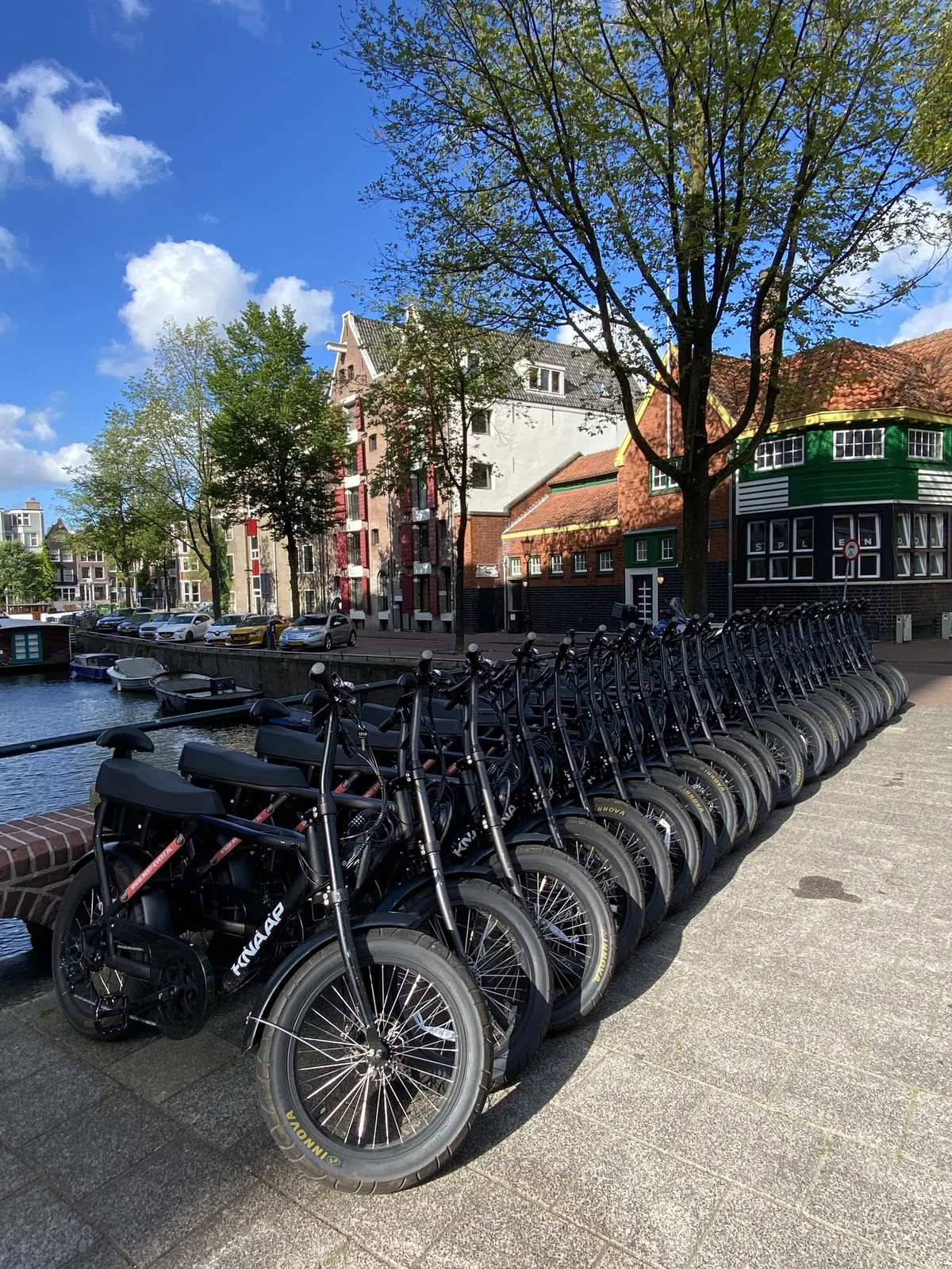 Fatbikes aan gracht in Amsterdam op zonnige dag — E-Choppershuren.nl